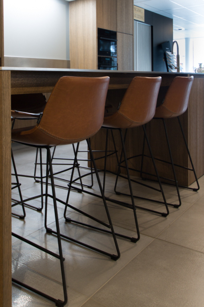 Eethoek met leren barkrukken en een houten keukeneiland, ontworpen voor comfort en stijl.