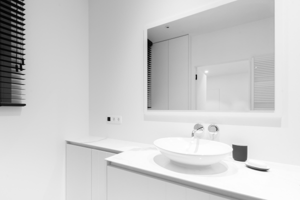 Moderne witte badkamer met spiegel en maatkasten
