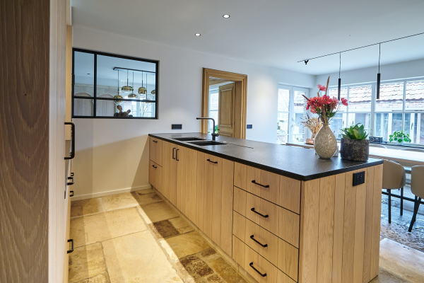 Stijlvolle keuken met op maat gemaakte vitrinekasten en een elegante combinatie van hout en glas.